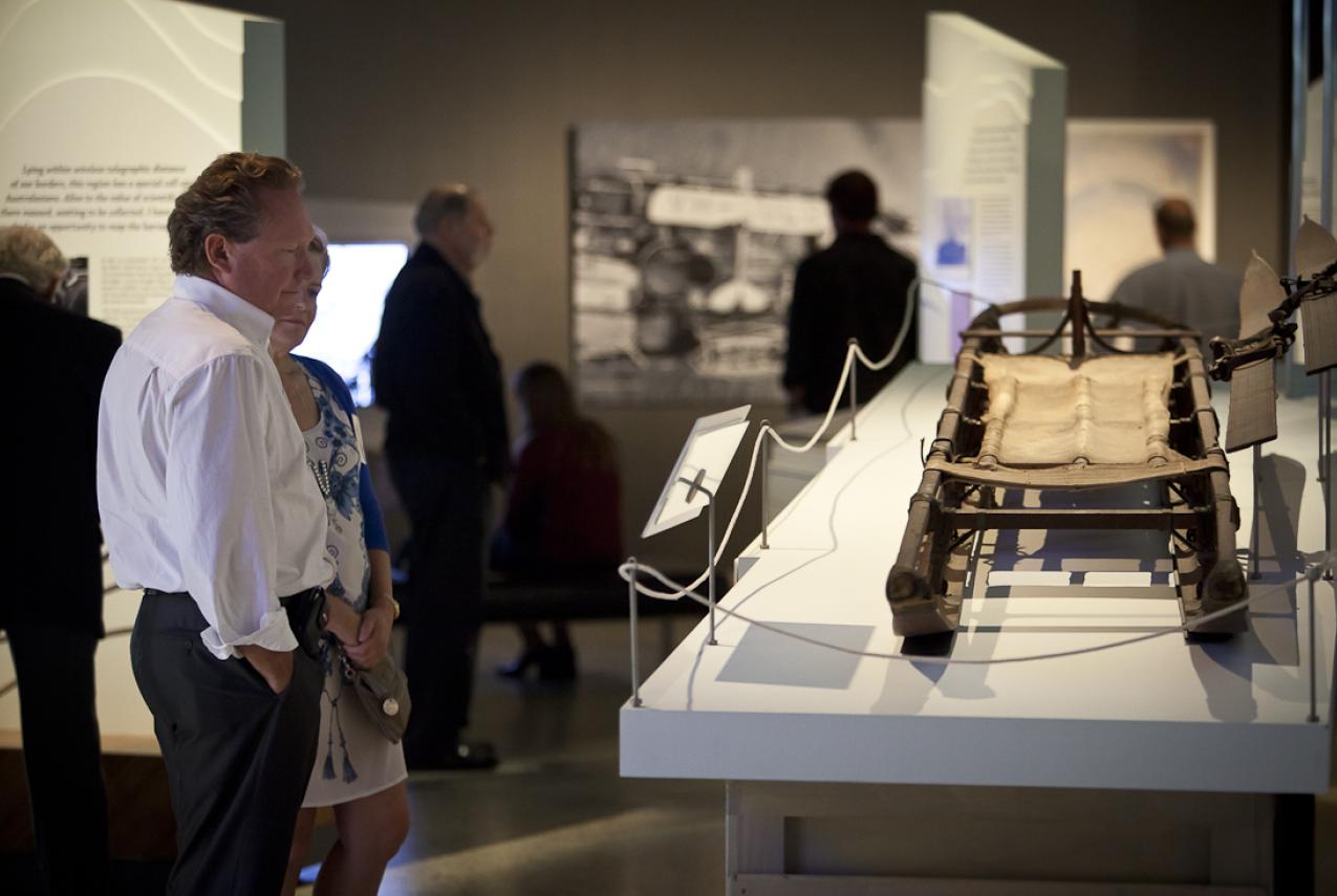 Visitors inspecting a display at the exhibition Traversing Antarctica