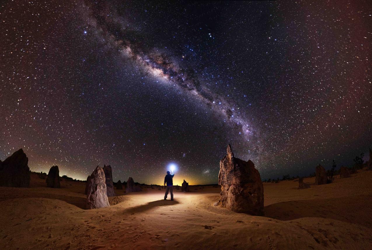 Man standing under night sky at Nambung National Park.