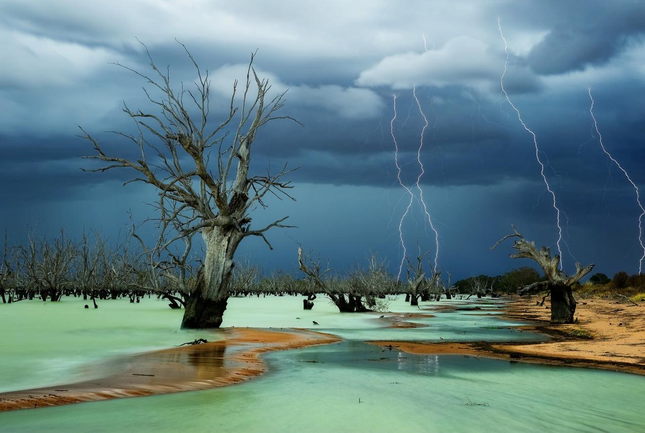 A dramatic storm taking place over a stark Australian outback lanscape