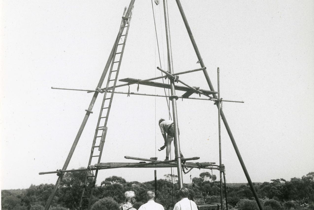A black and white picture from the early 1960s of a large wooden drilling frame