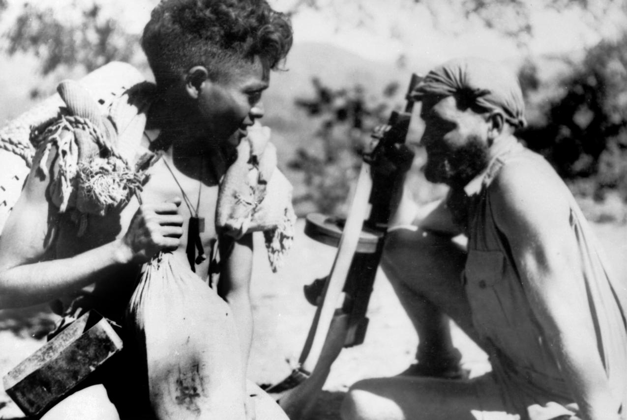 Australian soldier sitting next a criado during World War Two in East Timor