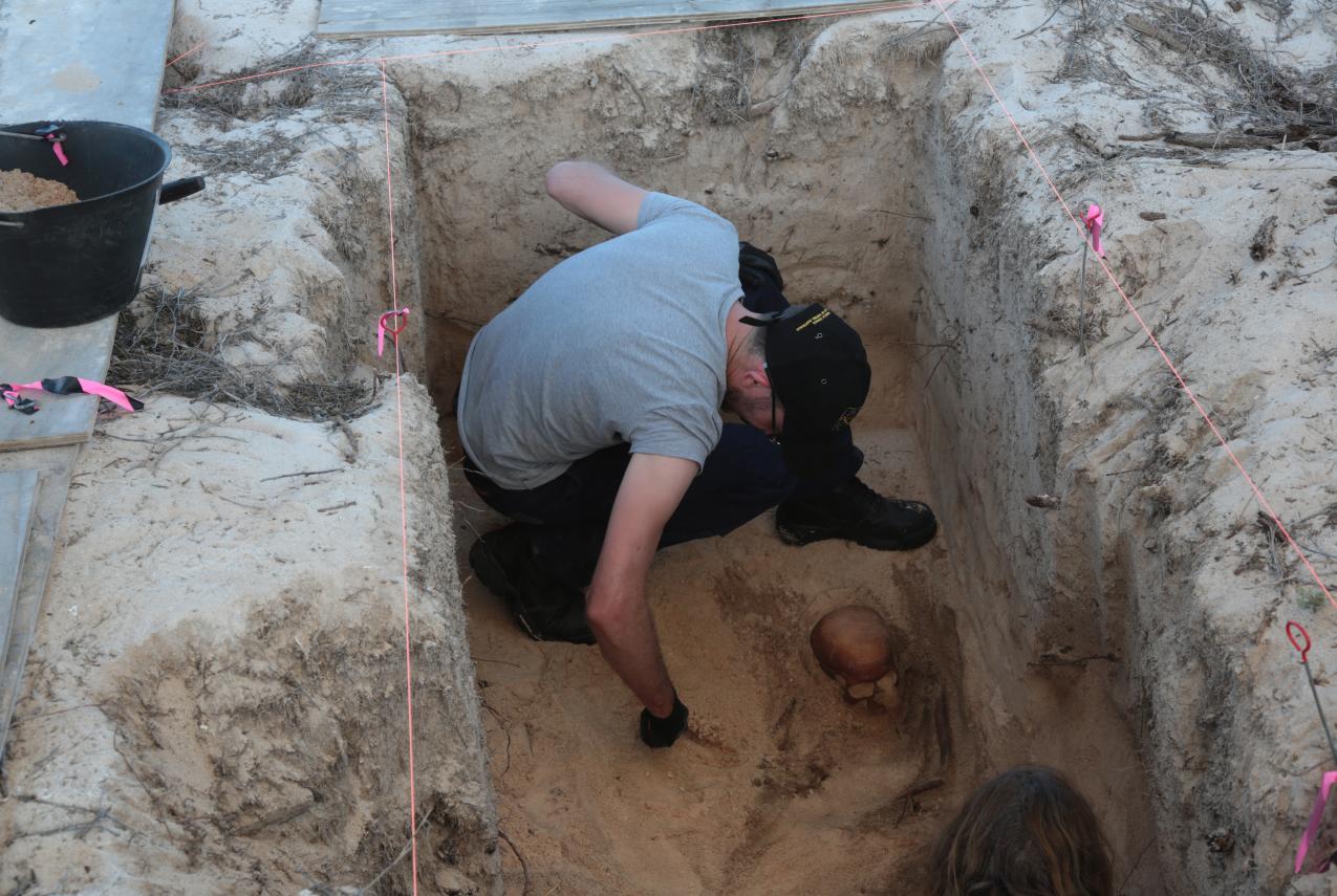 Archaeologist carefully excavating new burial site at Beacon Island.