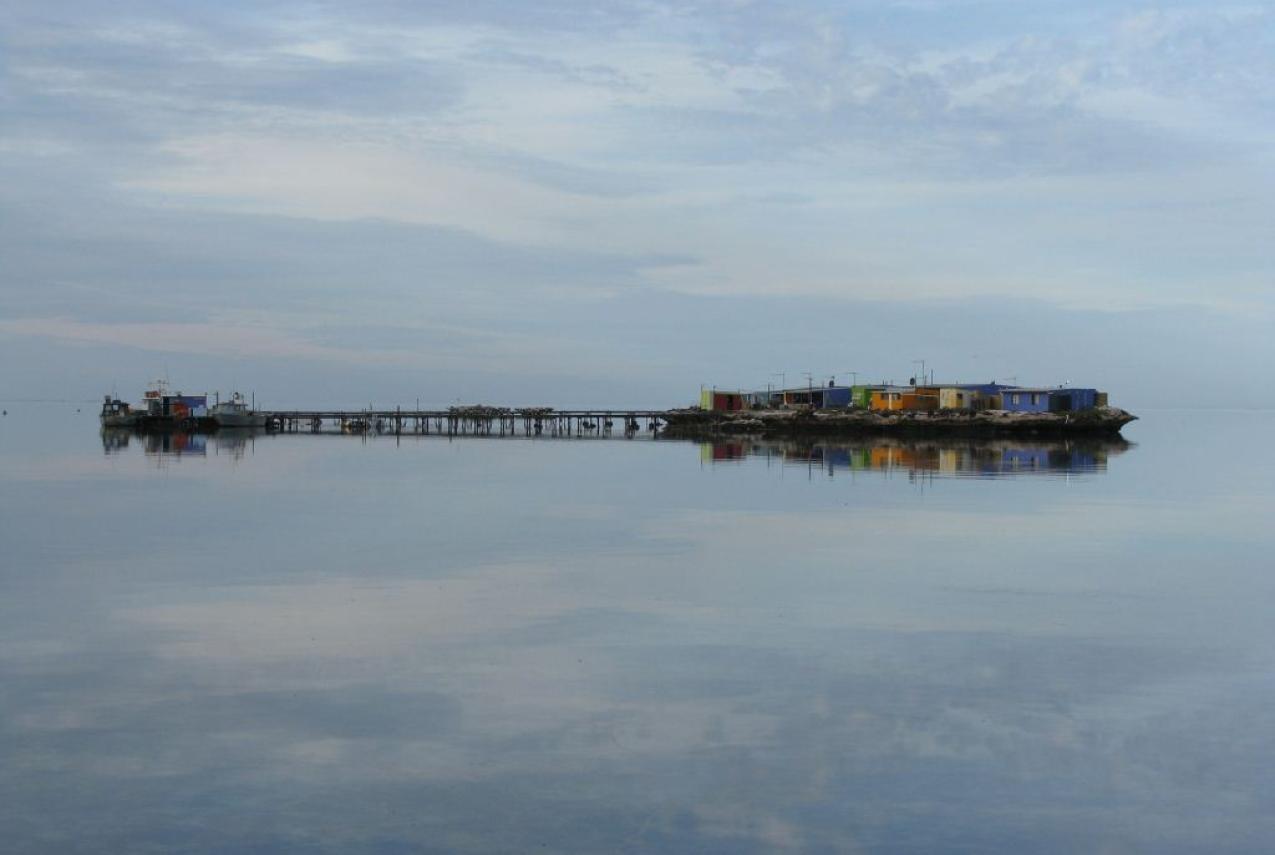A reflection of a pier on the calm waters