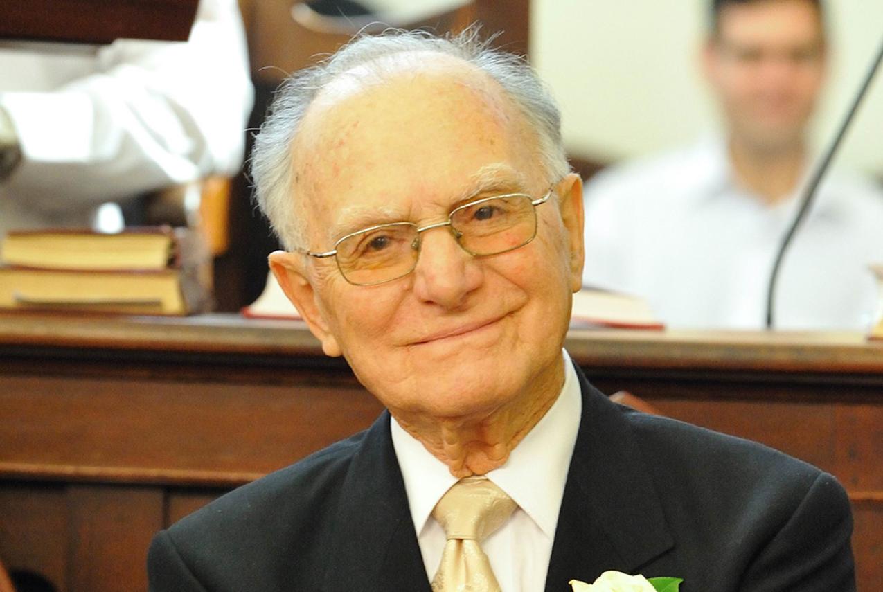 An older man in a black suit