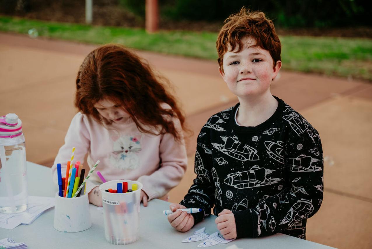 Photograph of a girl and a boy, aged 6, playing with space-themed crafts