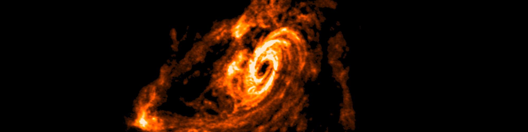 A photograph of space with a galaxy depicted in vibrant gold in the centre