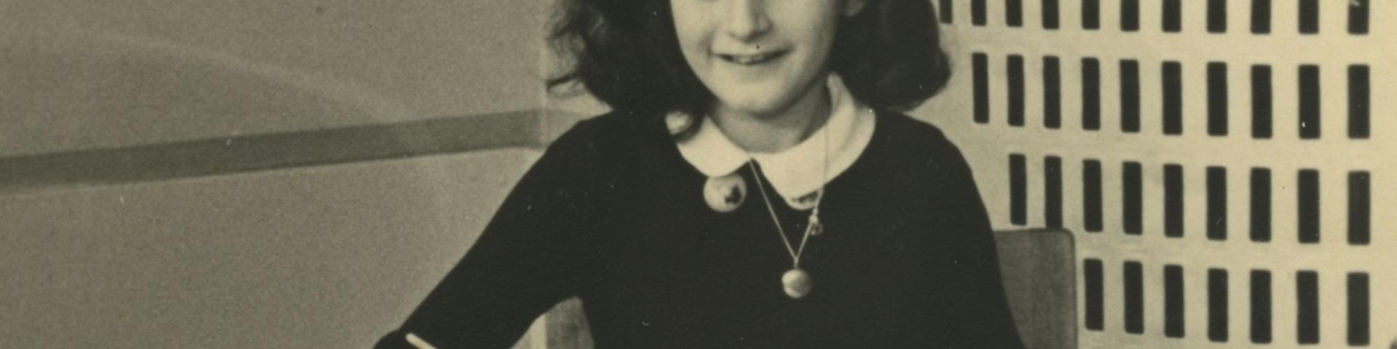 A photograph of a young girl sitting at a school desk