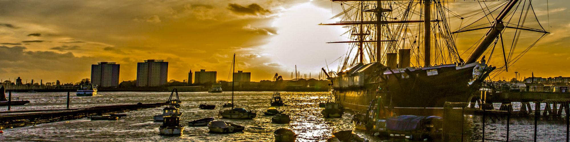 a sunset image of a ship in a marina 