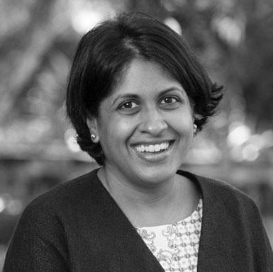 A black and white photograph of a smiling woman