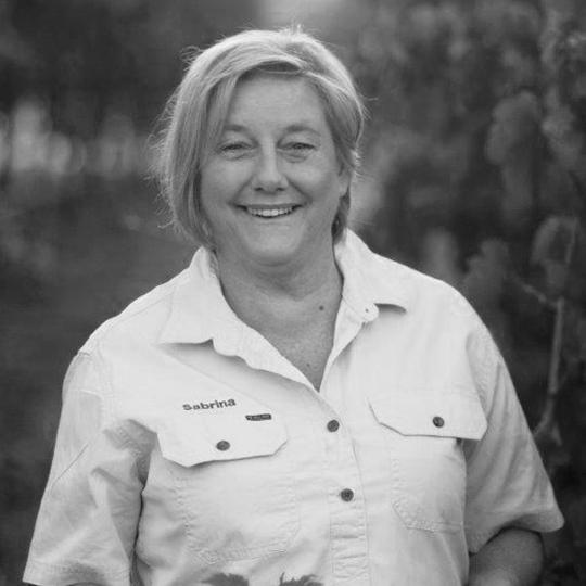 A woman with short fair hair smiles at the camera