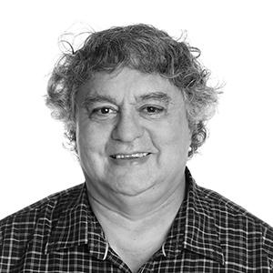 A black and white photo of a a man against a white wall