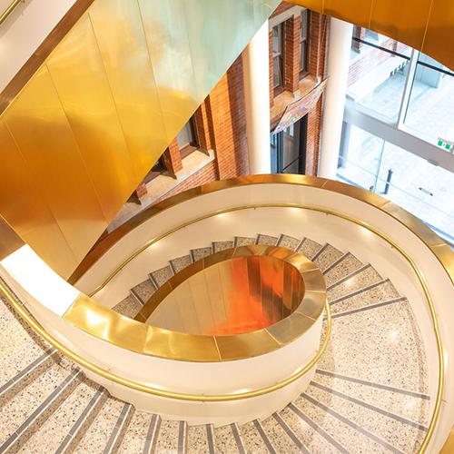 A gold spiral staircase photographed from above