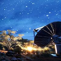 A satellite in the Australian desert turns up towards a starry sky