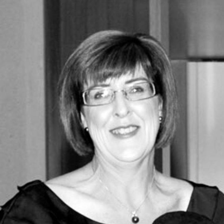 Image of a black and white female wearing a boat neck black shirt with glasses. 