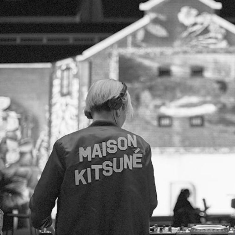 Black and white image of Miss Estonia DJ playing infront of a projected building