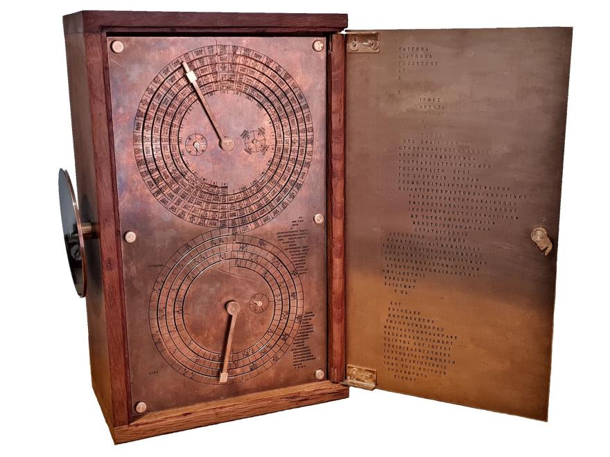 A brass model of the back of the Antikythera mechanism displaying two dials with Greek characters