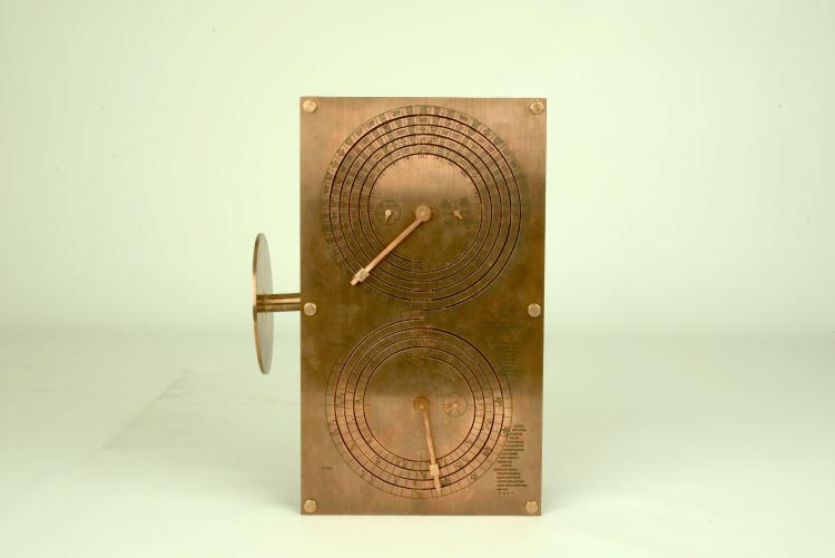A brass model of the Antikythera mechanism displaying two dials with Greek characters