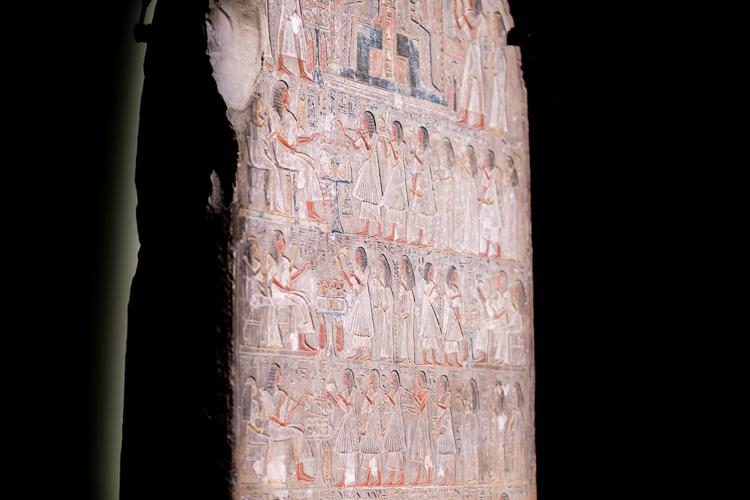 A side shot of a large Stela belonging to Huy which depicts five rows of Huy's family and descendents standing at offerings tables