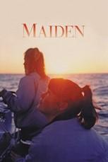 a image of two women on a yacht in the water as the sun is setting. One woman looks up to the sky and the other is steering the yacht