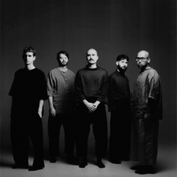 Several music performers posing in front of a black backdrop.