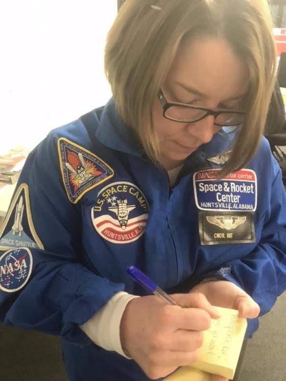 Female astronaut writing on a note pad