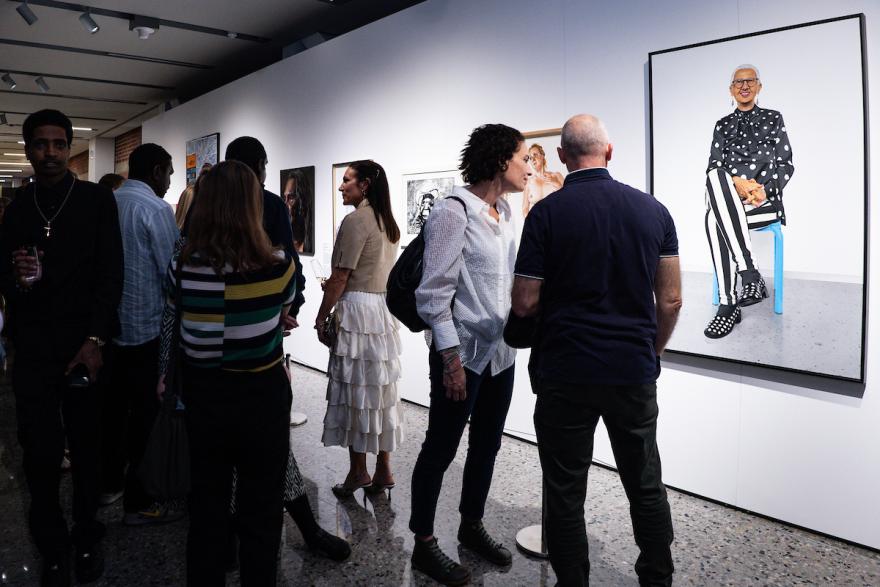 Lester prize portraits on display in gallery observed by visitors