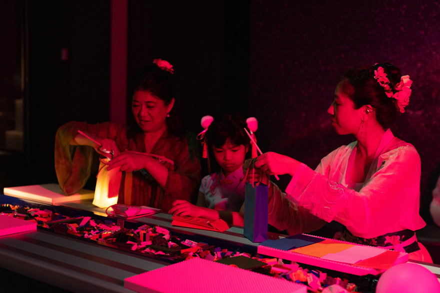 A group of 3 people making lanterns together