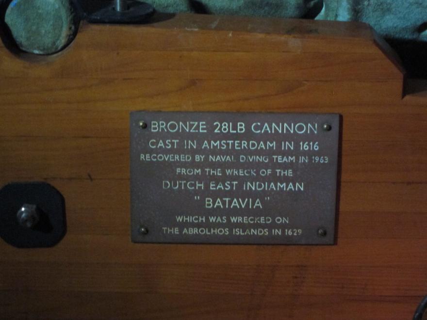 Plaque describing the history of a bronze 28lb cannon from the Dutch East Indiaman "Batavia." The text reads Bronze 28L cannon cast in Amsterdam in 1616 recovered by naval diving team in 1963 from the wreck of the Dutch East Indiaman "Batavia" which was wrecked on the Abrolhos islands in 1629.