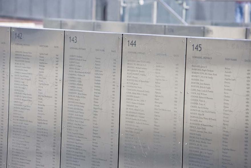 Several rows of engraved metal panels with the names of people and ships and dates