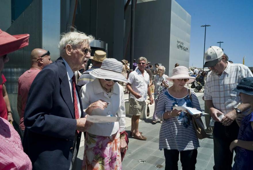 Several people in variously formal attire interact outside of the Western Australian Maritime Museum.