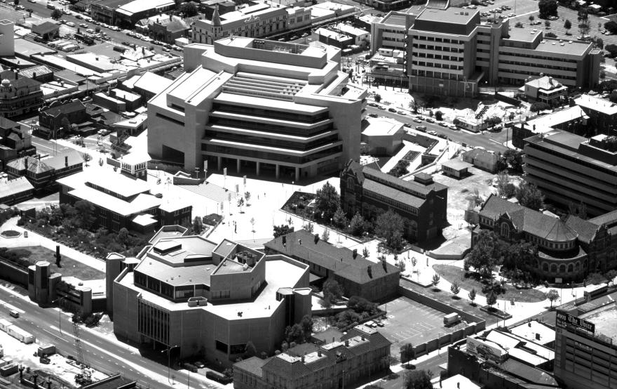 Black and white image of an aerial view of an urban area with modern and historic buildings.