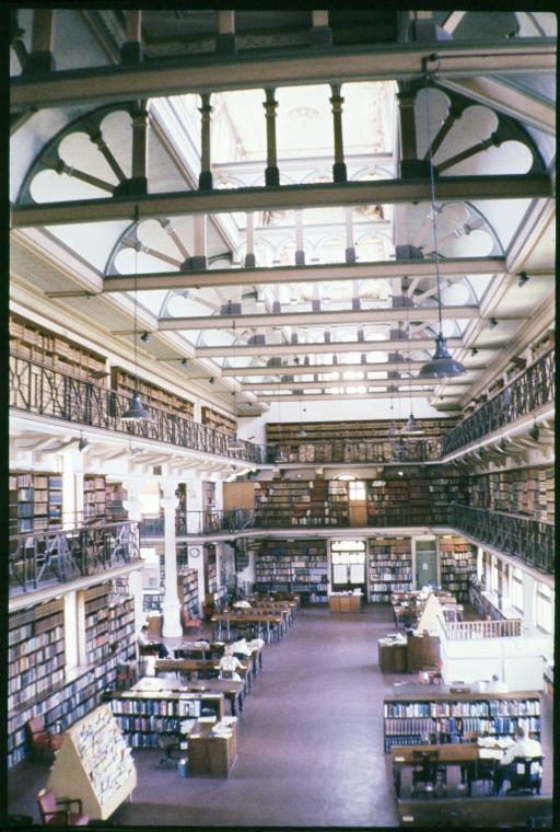 Interior of a multi-level library with bookshelves and reading areas.