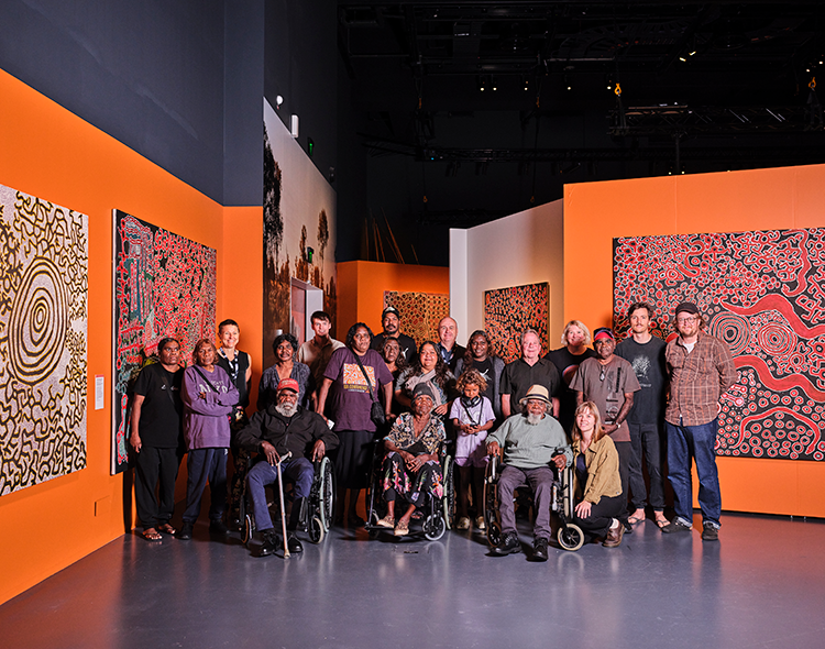 A group of Spinifex artists standing in the exhibition at WA Museum Boola Bardip