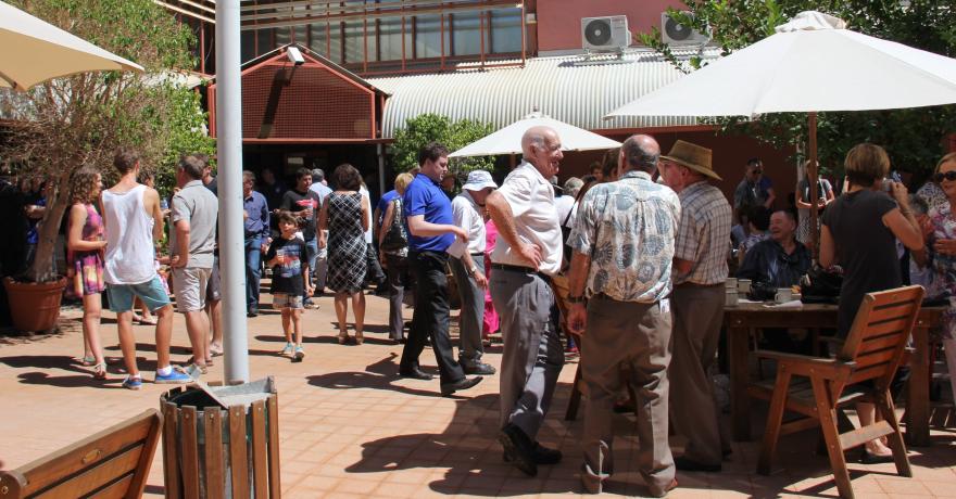 People enjoying morning tea in a sunny courtyard