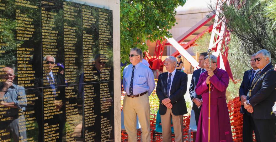 A group of people standing beside a memorial