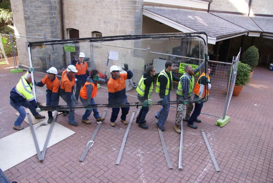 A group of people wearing high-viz lifting the lid of Megamouth's old tank