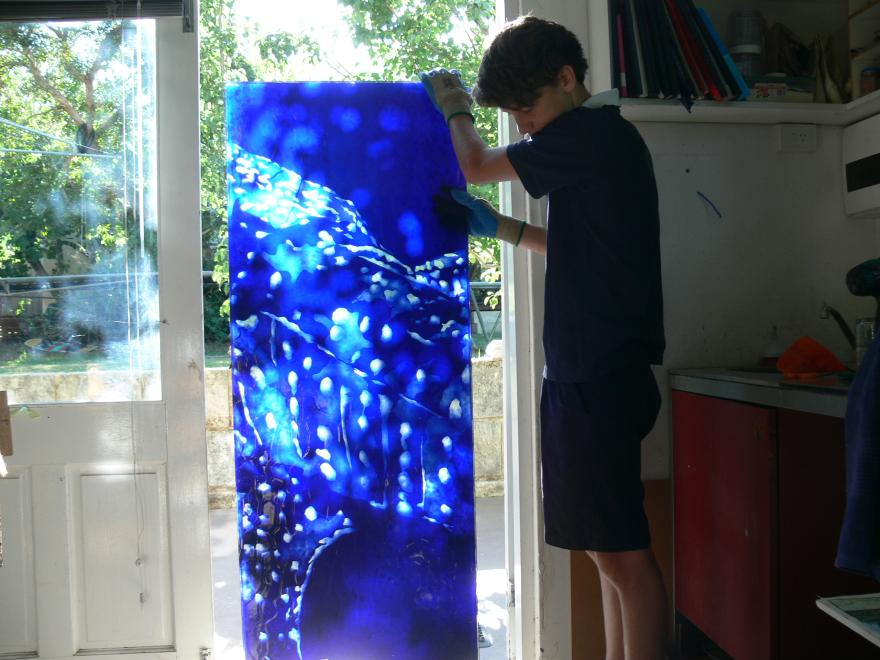 A person building the sculpture "Transparent Sea" in a glass workshop