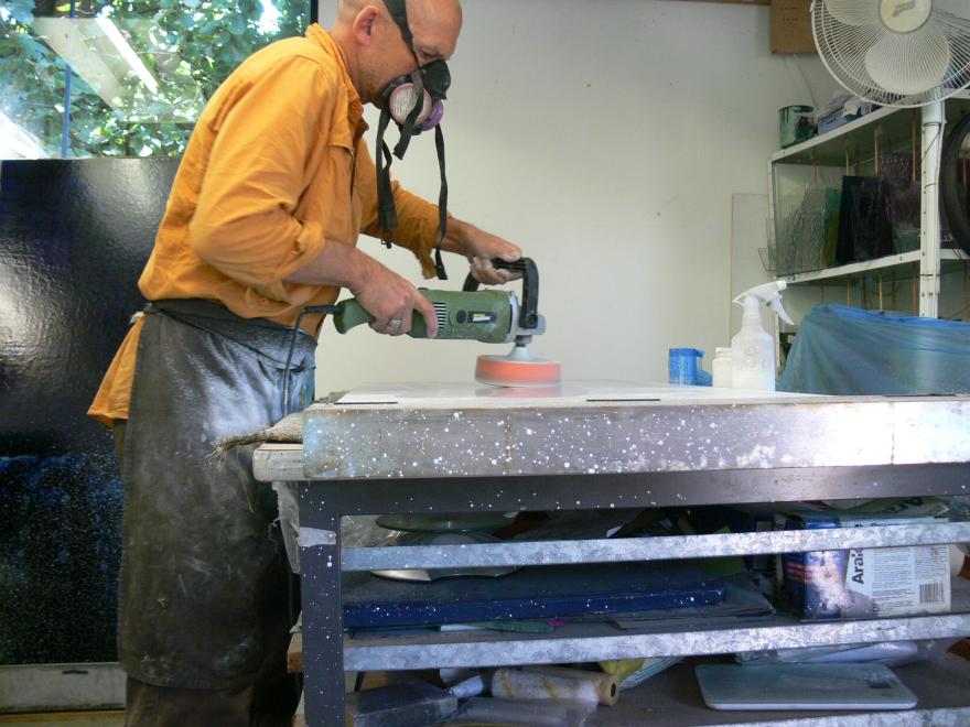 A person building the sculpture "Transparent Sea" in a glass workshop