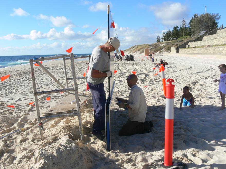Installing a glass sculpture at a beach for display