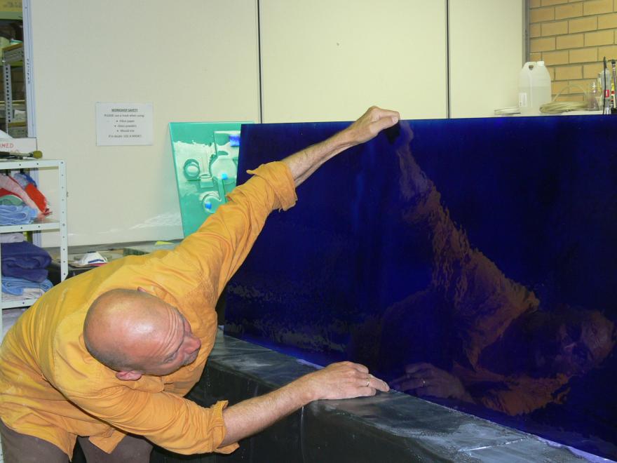 A person building the sculpture "Transparent Sea" in a glass workshop