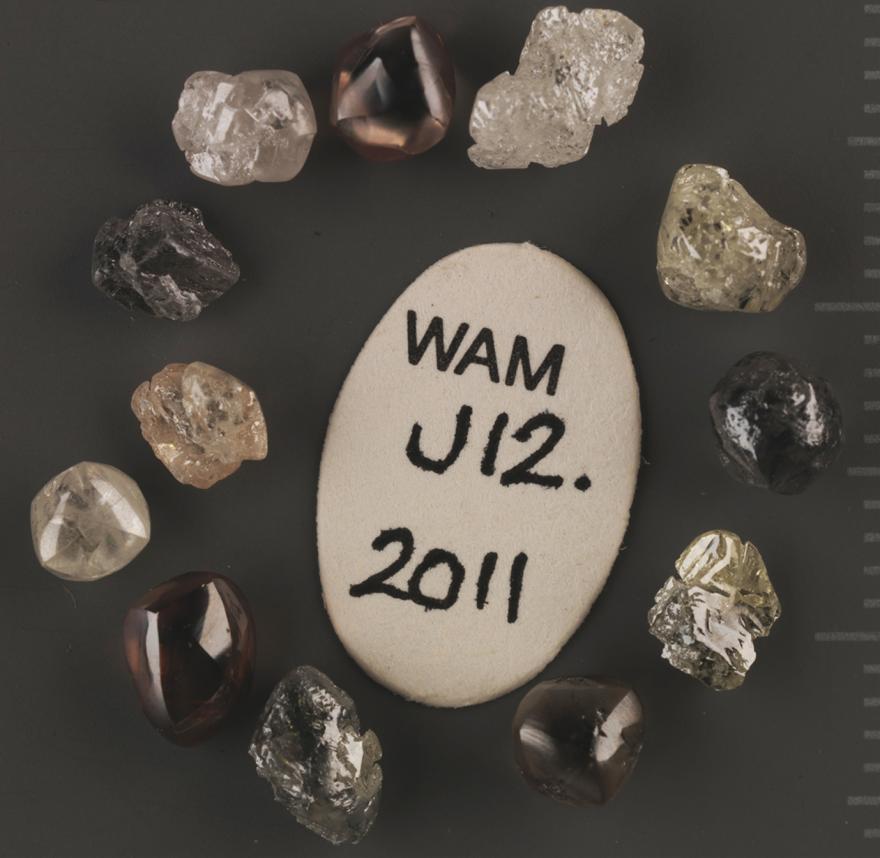 Yellow diamonds arranged around a stone that reads "WAM J12. 2011"