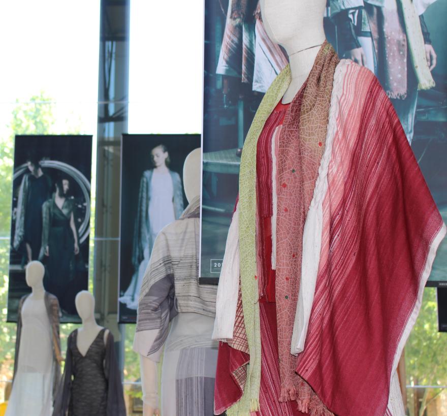 Mannequins wearing layered garments, with fashion posters in the background.