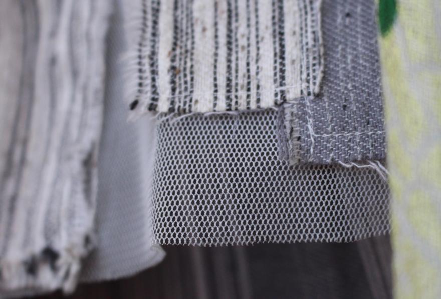 Close-up of overlapping fabrics with various textures and patterns.