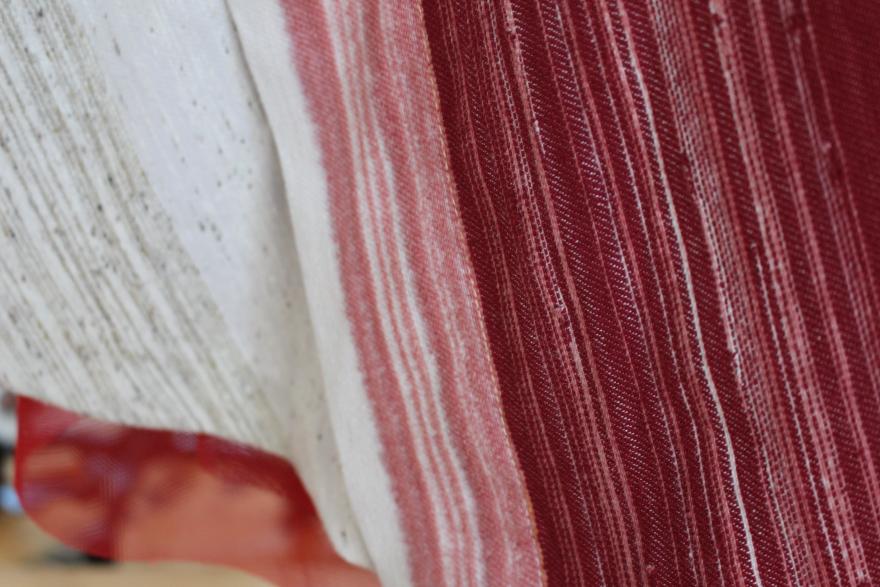 Close-up of beige and red striped fabrics with woven textures.