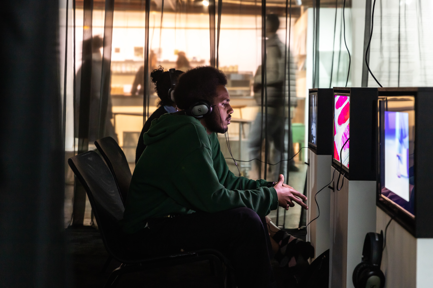 A person wearing headphones watching a screen in a dimly lit room