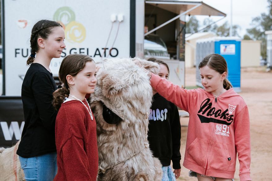 Three children with a lifesize camel puppet