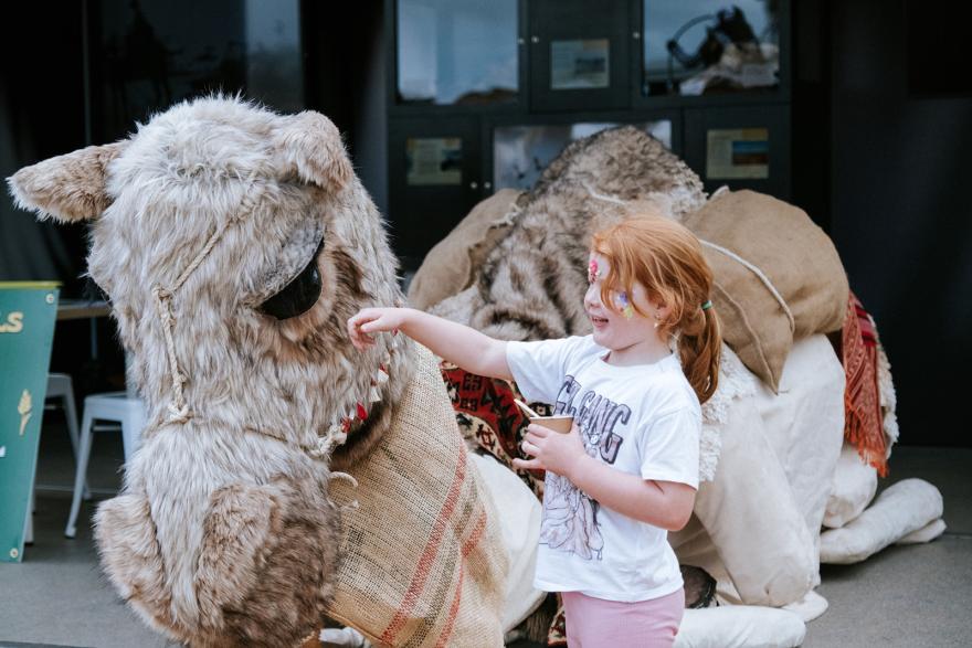 Young girl with lifesize camel puppet