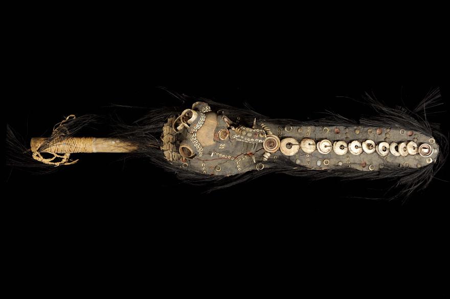 A rare Spirit flute from the Yuat River area. The piece features a long mud mask connected to a wooden pole. Front view.