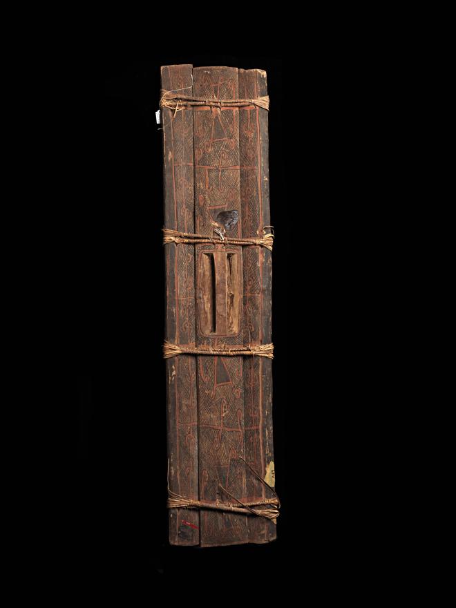 An intricately designed War shield, featuring three wooden logs tied together. From Arawe, West New Britain. Front View.