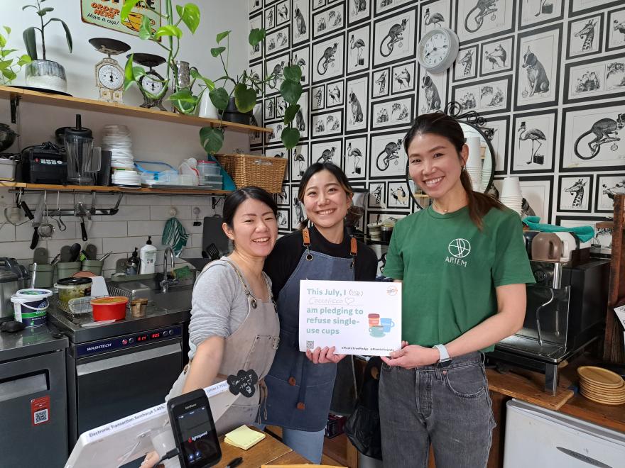 People holding up a Plastic Free July pledge